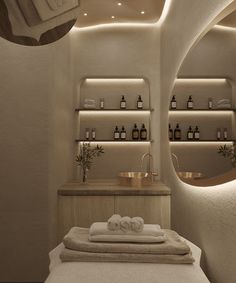 a spa room with white towels and bottles on the counter, along with shelves filled with personal care items