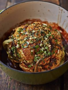 a pot filled with food sitting on top of a wooden table