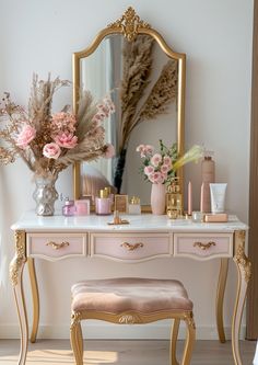 a dressing table with flowers, candles and a mirror in the corner next to it