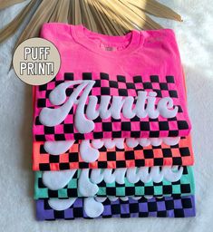 Our retro checkered auntie shirt is the perfect gift for all the new aunt's out there! Made on the soft comfort colors brand, these puff print tees are sure to be a summer favorite for all the auntie's! ★UNISEX T-SHIRTS-Run true to size.  If wanting a more oversized look, selecting 1 or 2 sizes up is recommended. ★How to order- 1. Select Size and Shirt Color-add to cart. 2. If wanting a different text (other than auntie)-click "add personalization" - enter custom text. Click add to cart. ★Care I Easy Shirt Designs Cricut, Personalized Shirt Ideas, Puff Vinyl Shirt Designs, Puff Print Design, Oversized Tshirt Design Ideas, Puff Vinyl Ideas, Tshirt Print Ideas Graphic Tees Shirt Designs, Puff Vinyl Shirt Ideas, Puff Print Tshirt