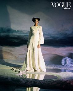 a woman in a white dress is standing on the ice with her hair pulled back