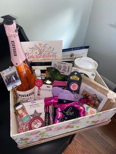 a gift box filled with wine, liquor and other personal care items sitting on top of a table