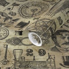 the wallpaper has many drawings on it and there is a paper roll in front of it