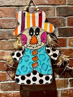 a wooden scarecrow hanging on a brick wall