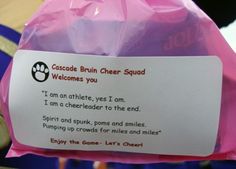 a person holding up a pink bag with a sign on it that says welcome to the brownie cheer squad