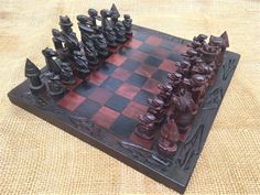 a wooden chess board with many pieces on it