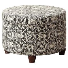 a black and white ottoman with wooden legs