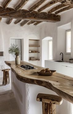 a kitchen with an island made out of wood and white walls is pictured in this image