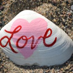 a rock with the word love painted on it and a pink heart in the middle