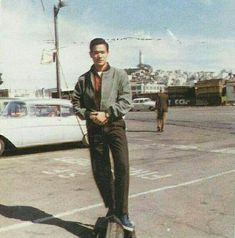 a man standing on top of a skateboard in a parking lot