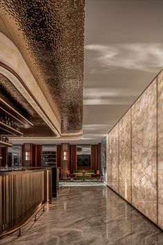 the interior of a modern restaurant with marble walls and flooring, along with an elegant bar