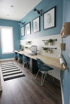 a room with blue walls and pictures on the wall, along with several desks