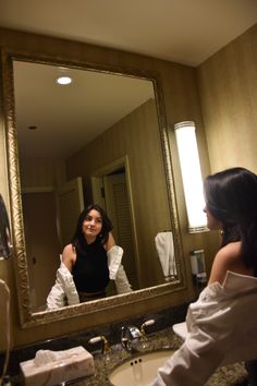 a woman is looking at herself in the mirror