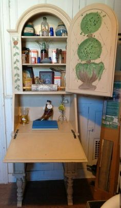 an old desk is in the corner of a room with shelves and cupboards on it