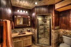 a bathroom with wood paneling and tile flooring on the walls, along with a walk in shower