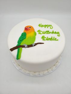 a birthday cake decorated with a bird on a branch