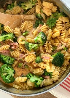 a pan filled with pasta and broccoli on top of a table