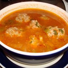 a bowl of soup with meatballs and broccoli