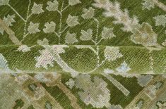 close up view of green and white carpet with floral design on the bottom, from above