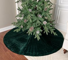 a christmas tree with cones and pine cones on the top is surrounded by green velvet