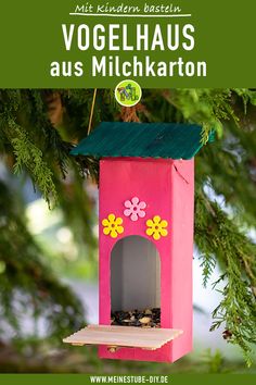 a pink birdhouse hanging from a tree with the words vogelhauss aus mickrarton on it