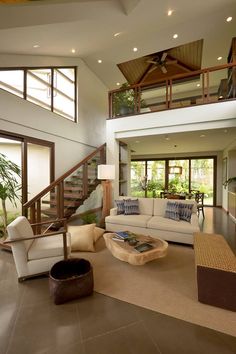 a living room filled with furniture next to a stair case in front of a window