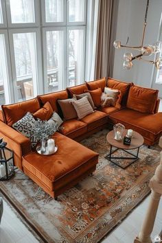 a living room filled with lots of furniture next to large windows on top of a rug