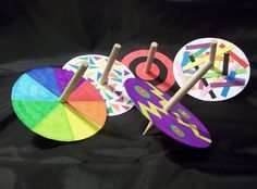 three different colored paper circles with sticks sticking out of the middle and one on top