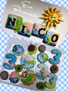 an assortment of decorated cookies in the shape of numbers and animals on a blue checkered tablecloth