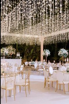 an outdoor wedding reception with chandeliers and tables