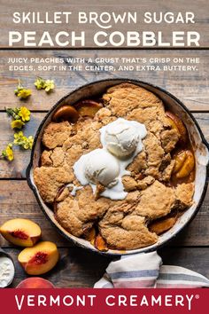 a skillet with ice cream and peach cobbler in it on top of a wooden table