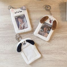 three keychains with pictures of people and animals on them sitting on a table