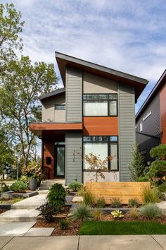 a modern house is shown with landscaping in the front yard