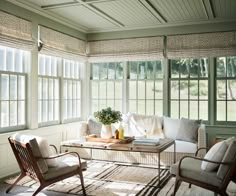 a living room filled with furniture and windows covered in blinds on top of each window