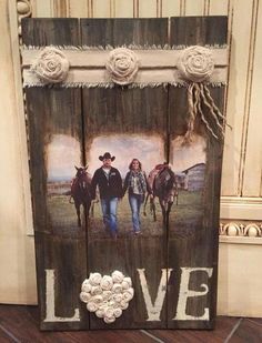 a wooden sign with two horses and the word love painted on it's side