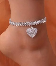 Add a touch of shimmer to your ankles with our Rhinestone Heart Dangle Anklet! This delicate ankle bracelet features a heart-shaped pendant and chain adorned with shiny rhinestones. Designed to sit just above the ankle bone, it's the perfect accessory to elevate any summer look. (Cute, right?!) Materials: Metal Alloy. Extra coating plating 0.05ml thickness for long lasting shine. Nickel Free and Rhinestones Pendant Size: .85" X .80" (approx.) Rephrase with Ginger (Ctrl+Alt+E) Silver Alloy Anklet As Gift, Silver Heart Anklets For Party, Silver Anklets For Valentine's Day Party, Elegant Silver Alloy Anklets, Party Alloy Anklets, Silver Heart Bracelet With Rhinestones, Heart Bracelet For Party, Silver Anklets With Heart Charm For Valentine's Day, Elegant Heart-shaped Anklets For Party