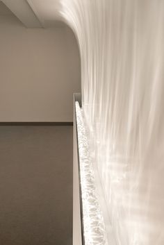 an abstract white sculpture is shown in the middle of a room with light coming from it