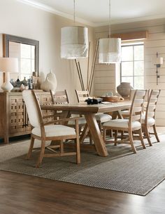 a dining room table and chairs in front of a window