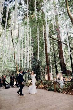 a bride and groom dancing in the woods surrounded by white icicles hanging from trees