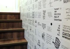 the wall is covered with many different types of stickers and writing on it, along with some stairs