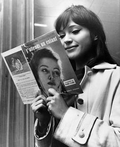 a woman reading a magazine while holding up her hair