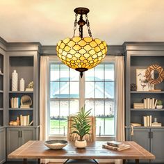 a dining room table and chairs with a chandelier hanging from the ceiling over it