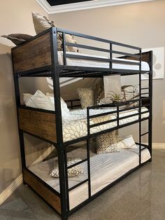 a bunk bed with two sets of mattresses and pillows on it in a room