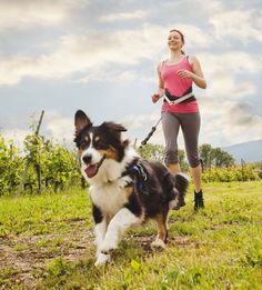 a woman running with her dog on a leash