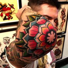 a man with a flower tattoo on his arm