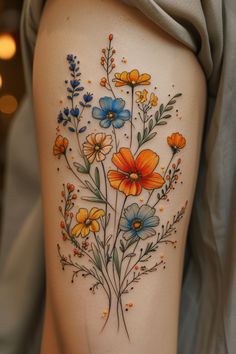 a woman's thigh with flowers painted on it and an orange flower in the center