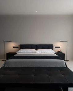 a large bed sitting in the middle of a bedroom next to two lamps on either side of it