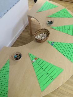 a wooden table with several pieces of paper cut out to look like christmas trees on it