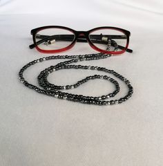 Sunglasses chain Eyeglasses chain Glasses necklace Glasses holder This chain is made of black glass beads and silver hematite beads with a diameter of 4 mm. The metal parts and buckle are stainless steel. The chain is ideal for all people who wear glasses and often have to take off their glasses. Simply hang them on the necklace and they are  always with you. This is a wonderful fashion detail because the chain-necklace is very effective and modern. You can give it to your mother, sister, wife, grandmother ... If you buy this chain, it comes in a nice gift box. We send all shipments by registered mail with a security tracking code. Thanks a lot for visiting! FREE SHIPPING! Black Glass Necklaces, Black Round Glass Necklaces, Black Adjustable Glasses Chain For Parties, Elegant Black Glasses Chains For Party, Beaded Metal Glasses Chains For Party, Metal Glasses Chains As Gift, Metal Glasses Chain With Adjustable Chain As Gift, Metal Beaded Glasses Chains For Party, Black Metal Glasses Chain With Adjustable Feature