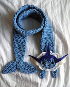 a crocheted blue and white scarf with an origami shark on it